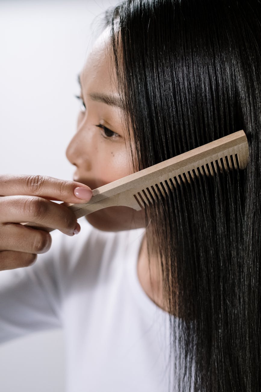 woman in white crew neck shirt combing her hair