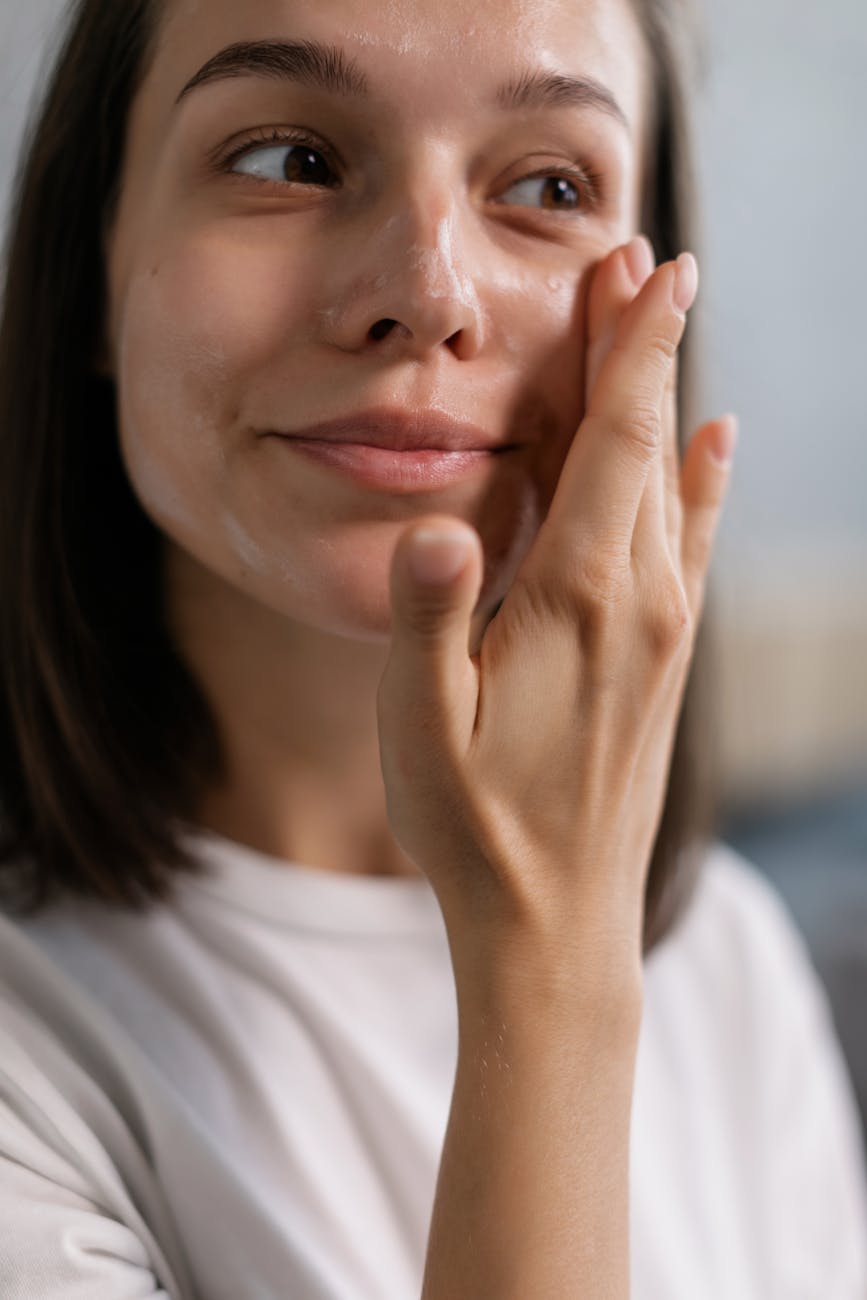 a woman applying a facial product