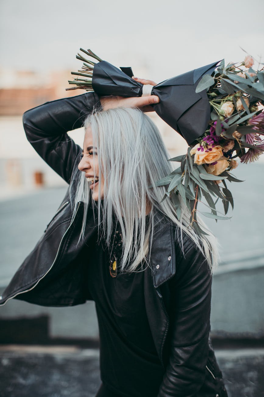 woman wearing black leather jacket holding flower bouquet