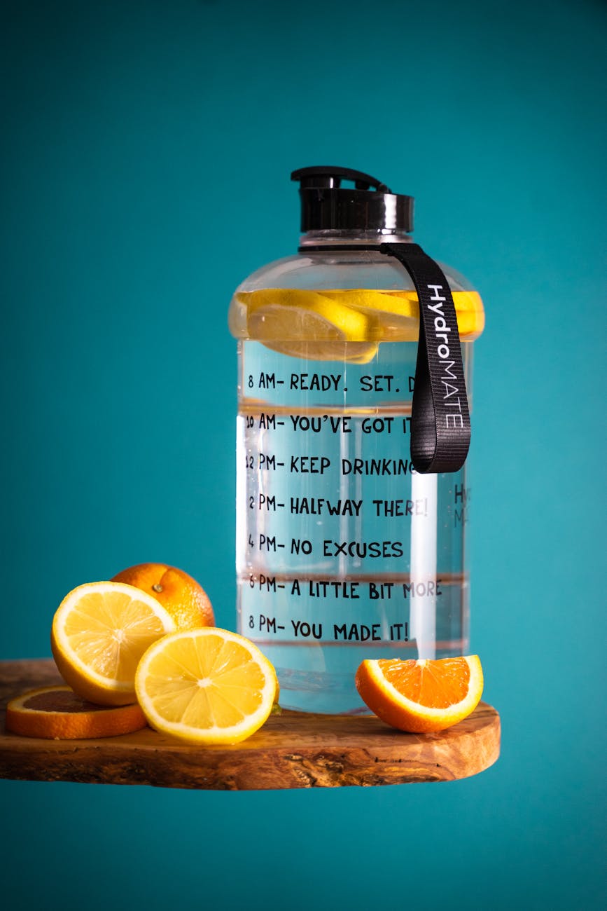 slice lemon beside glass pitcher on wooden table